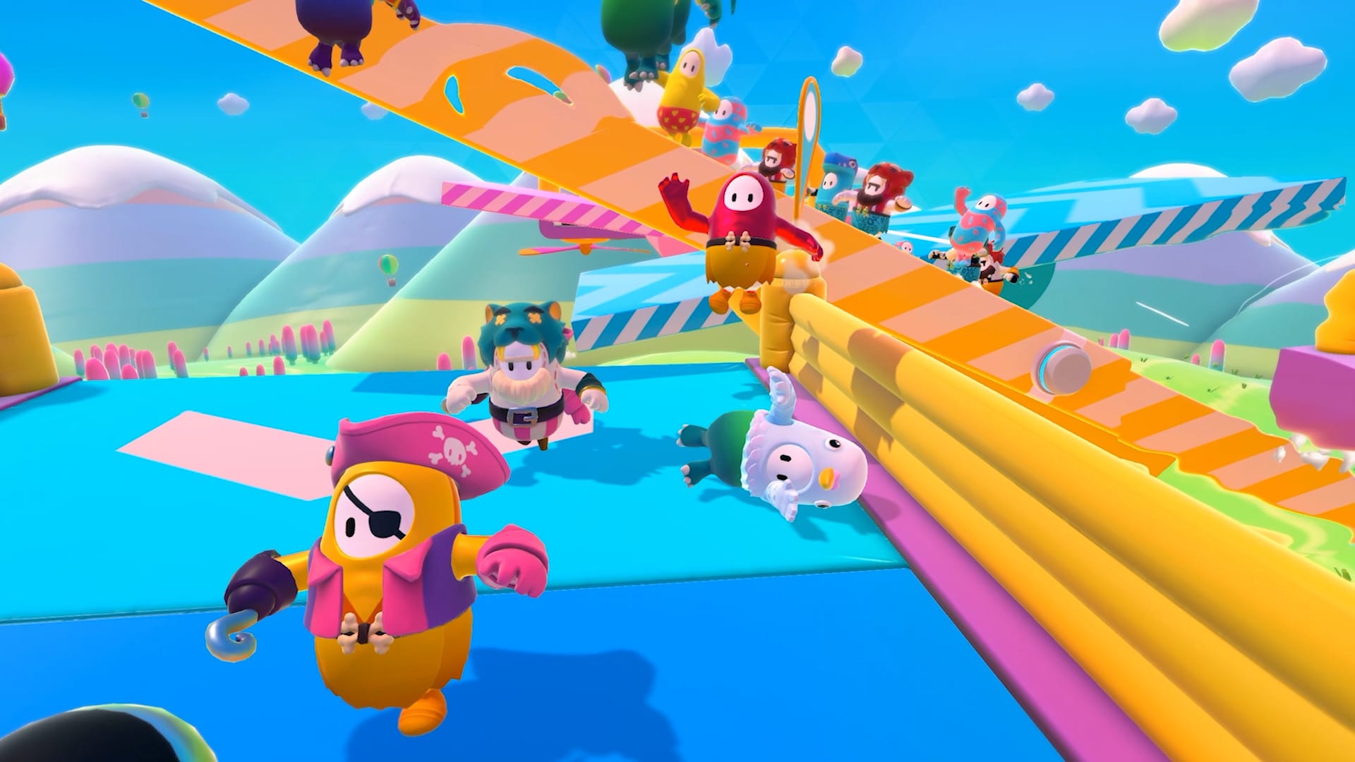 Several brightly colored figures in various costumes running through a padded and rubberized obstacle course in the game Fall Guys. One of the figures is toppled on their side.